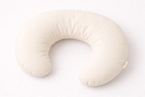 Naya Baby organic cotton nursing and feeding pillow C-shaped oat cream white linen flat lay